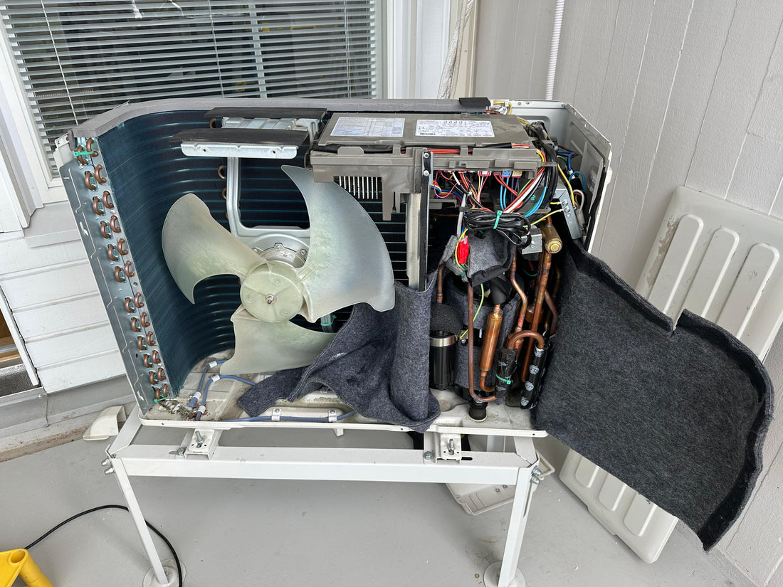 Ilmalämpöpumpun ulkoyksikkö aukaistu korjausta varten.