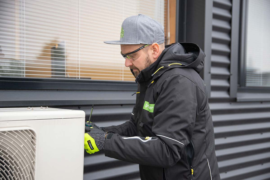 Asentaja vaihtamassa omakotitalon öljylämmityksen edullisempaan lämmitysmuotoon.